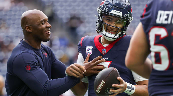DeMeco Ryans laughs as he grabs C.J. Stroud, who holds the ball in one hand.